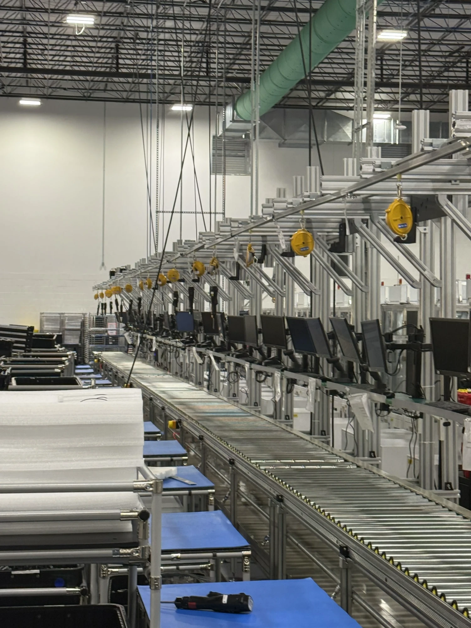 Row of workstations with balancers along a conveyor